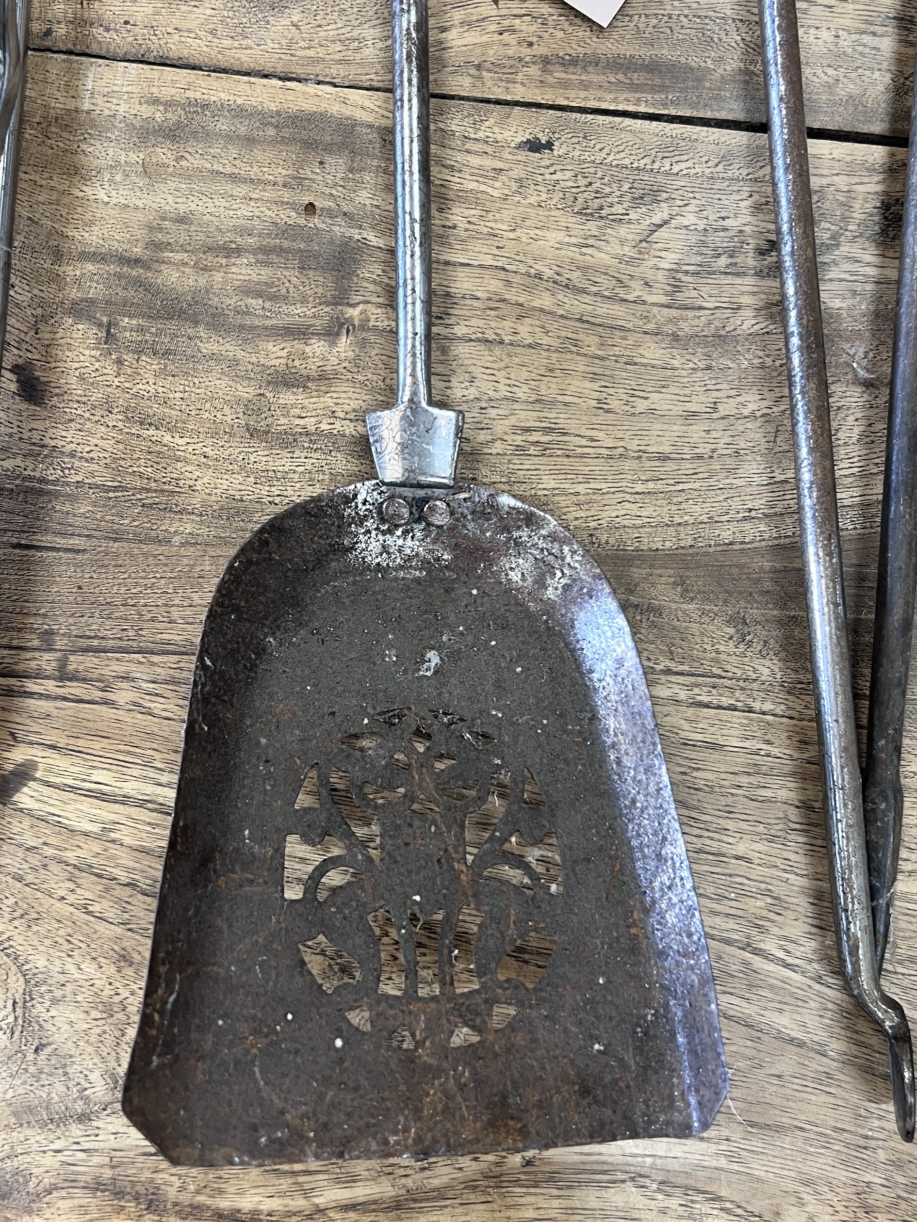 A set of three brass mounted steel fire implements together with a pair of tongs and a poker